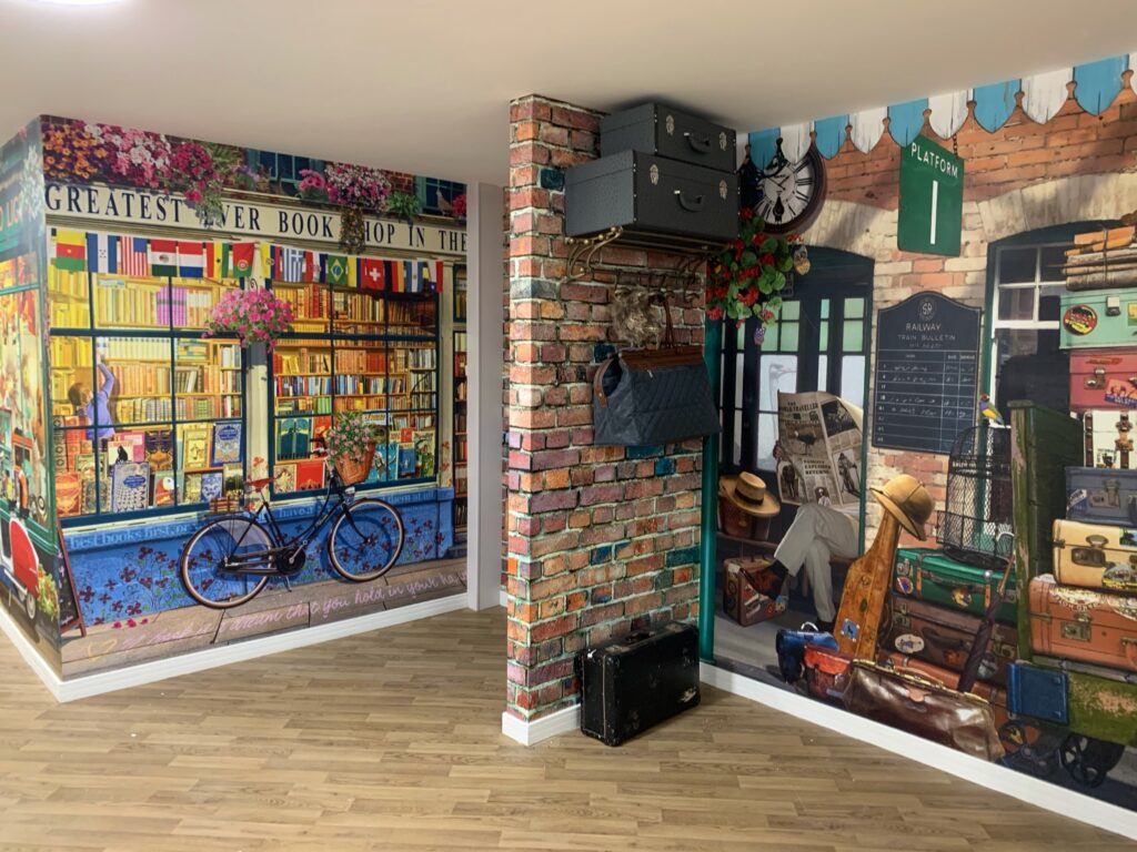 A corner with wallpaper featuring a railway station and a book shop at The Glen care home