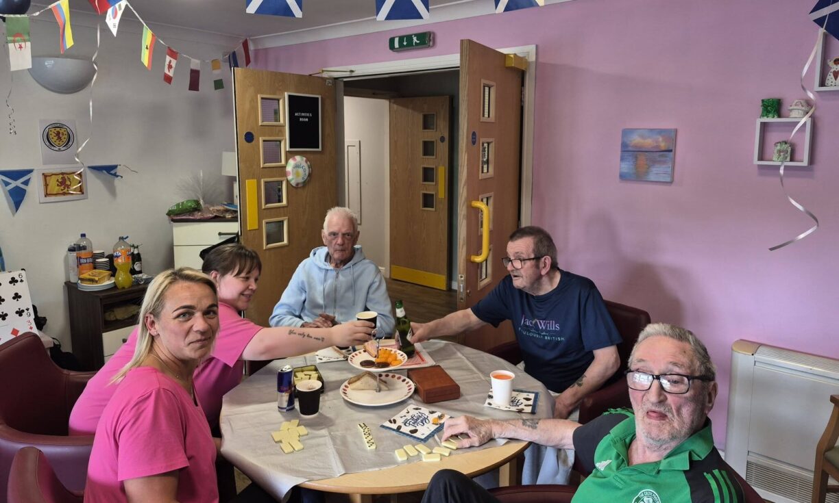 Resident sharing snacks and drinks with family during Father's Day celebrations at Carnbroe Care Centre