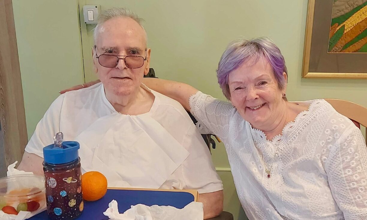 Resident smiling with family during Father's Day celebrations at River Brook care home