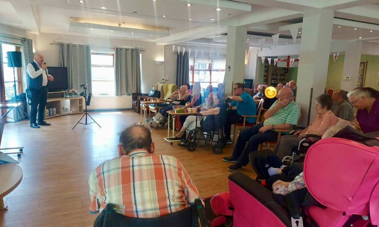 Residents and families enjoying an afternoon party with live music on Father's Day at River Brook
